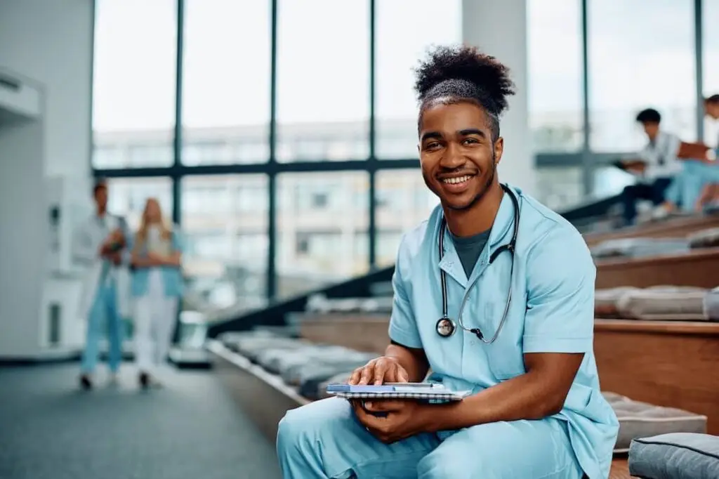 Happy African American nursing student studying at college and looking at camera. 