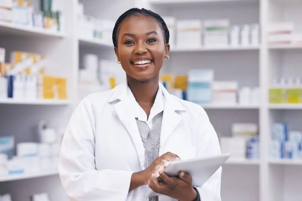 Portrait of black woman in pharmacy with tablet.