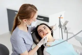 Portrait of smiling girl on a dental chair in dentistry.